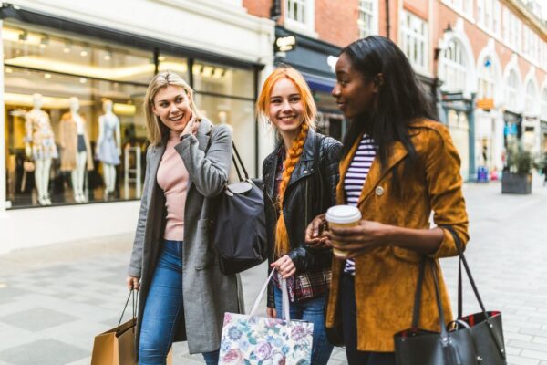 Three girls, multiracial group, having fun in the city while shopping