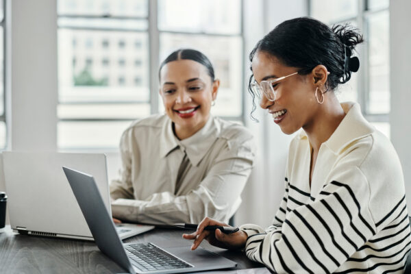 Business women, laptop and happy team in office for web design, collaboration, and training for customer service.
