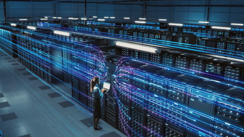 Female engineer in network server room with rows of servers connected together with glowing wiring representing networks