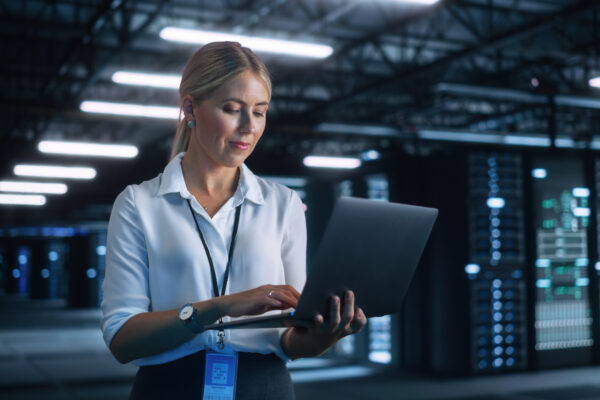 Portrait of Successful Female Chief Engineer or CEO Using Laptop Computer to Optimise Server Farm Cloud Computing Facility at the Evening Office