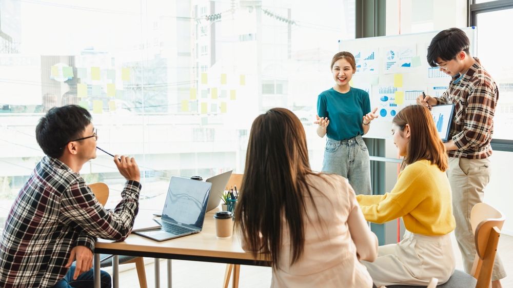 Mobile app development - Start up partners discussing the ideas for new strategy of development at nice near the white board flip chart in modern office