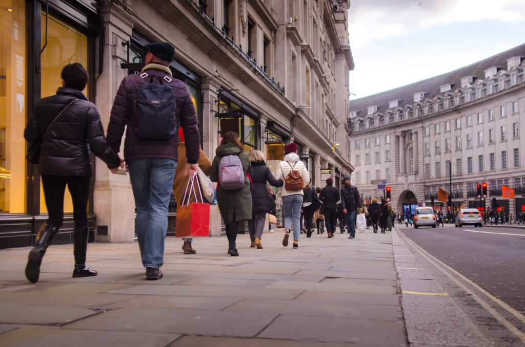 Footfall data -Busy city street with people walking, tall buildings, and cars in the background.