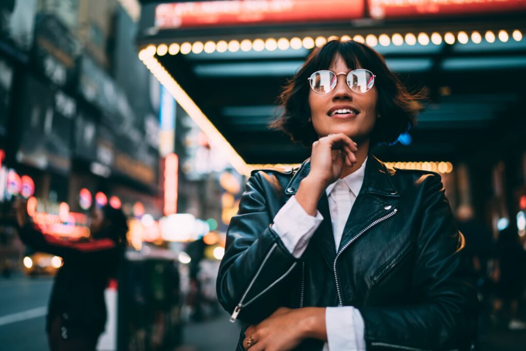 Location intelligence -Women standing on a city street at night, with blurred lights and buildings in the background.