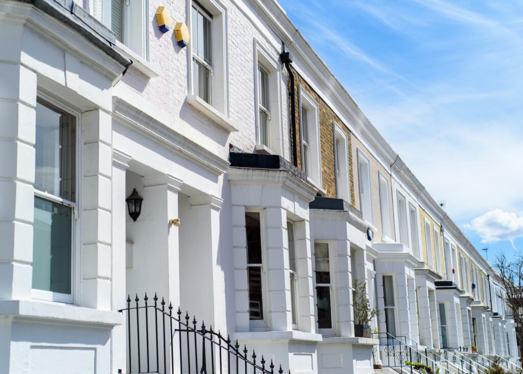 Geospatial analytics - Row of white terraced houses with large windows and black iron fencing.