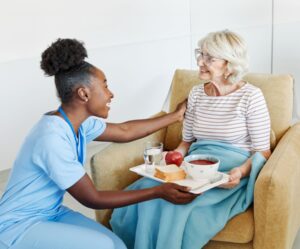 Care Quality Commission - Care worker giving a elderly woman a meal