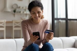 TSB - Woman buying a product online using her mobile phone and card