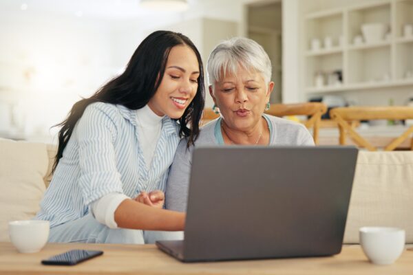 Care worker supporting elderly woman on her laptop