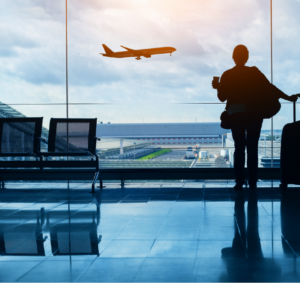 EasyJet - Female traveller looking at a plane departing in a airport departure room