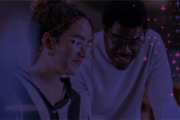Two colleagues working with each other at the office, looking at a screen