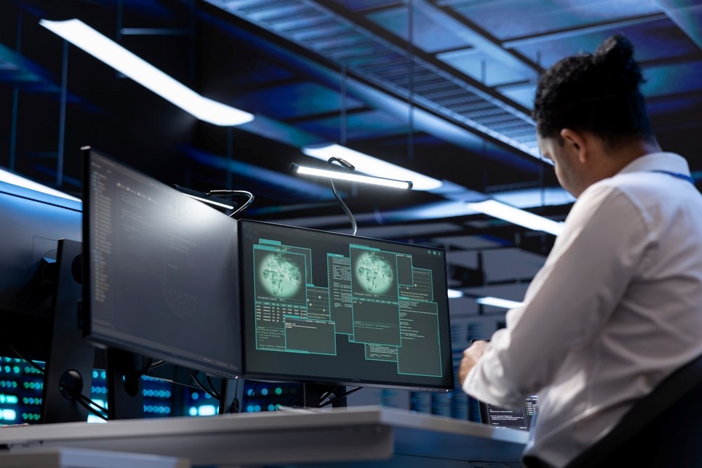 Managed SIEM Services - Software developer using computer in server room to support global connections using their hardware