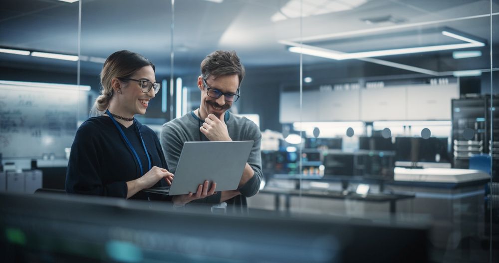 Managed SOC Services - Portrait of Two Creative Young Female and Male Engineers Using Laptop Computer to Analyze and Discuss