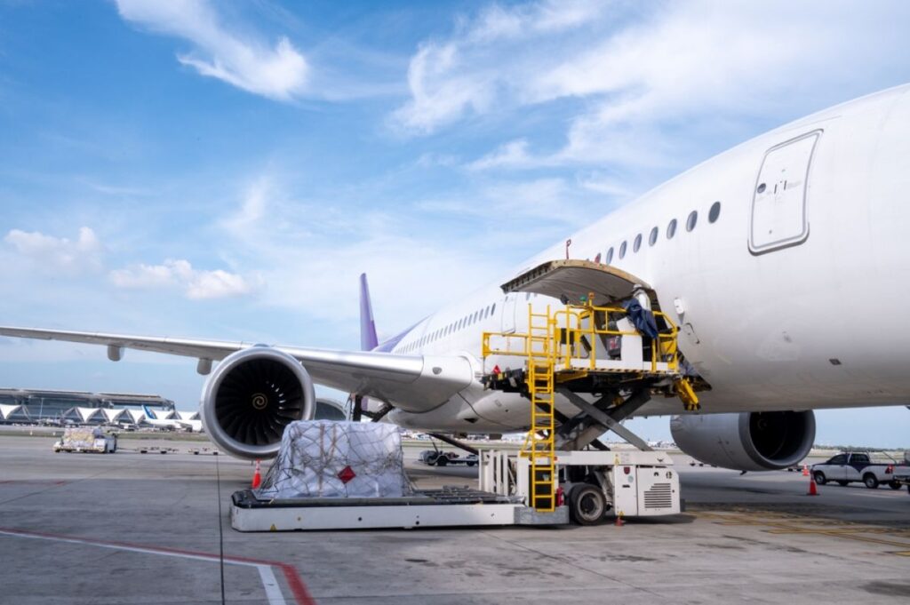 Air cargo logistic containers are loading to an airplane. Air transport shipment prepare for loading to modern freighter jet aircraft at the airport